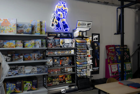 Toy store display with Warhammer kits, Citadel Colour paints, puzzle games, and model boxes