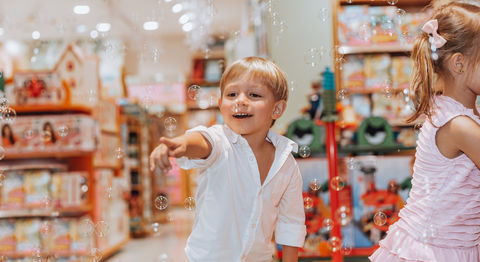 Two children playing with bubbles in a toy store.