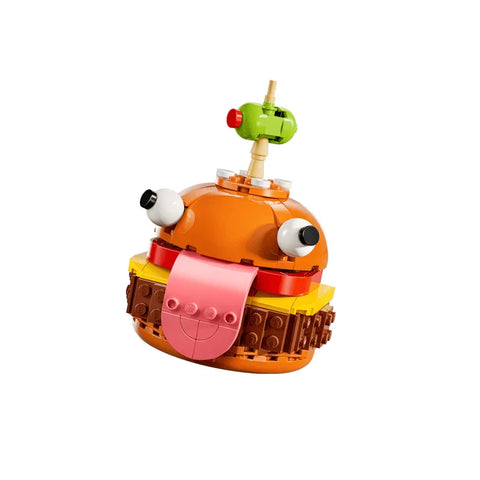 Lego burger toy with cartoon eyes and pink tongue, colorful building blocks