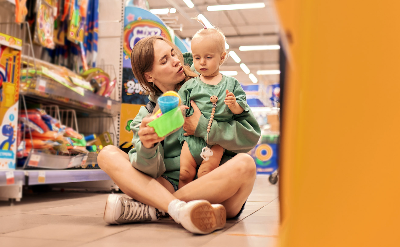 Woman holding a baby in a toy aisle of a store