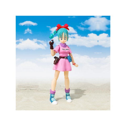 Anime action figure in pink dress with teal hair, posed outdoors under blue sky with clouds.