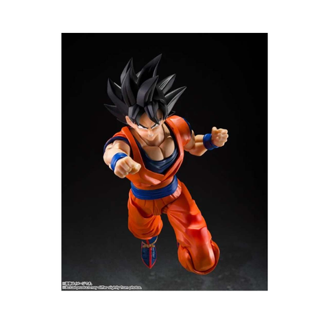 Anime action figure in orange outfit with spiky black hair, dynamic flying pose, collectible toy