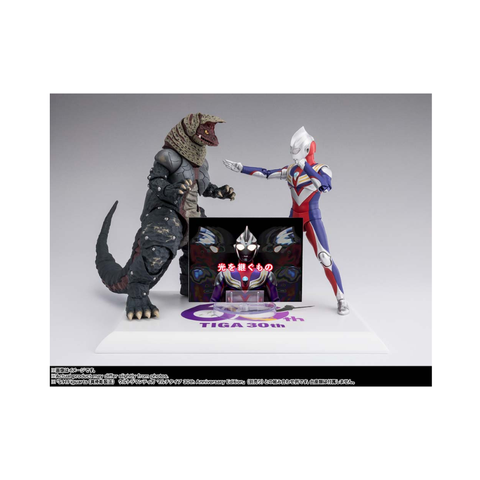 Ultraman Tiga and monster action figures on a display stand with Tiga 30th anniversary text.