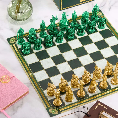 Luxury themed chess set with detailed gold and green pieces on a marble table