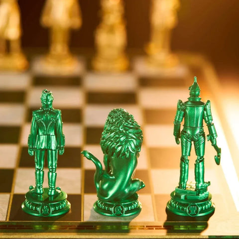 Green metallic wizard, lion, and robot chess pieces on a chessboard, close-up.