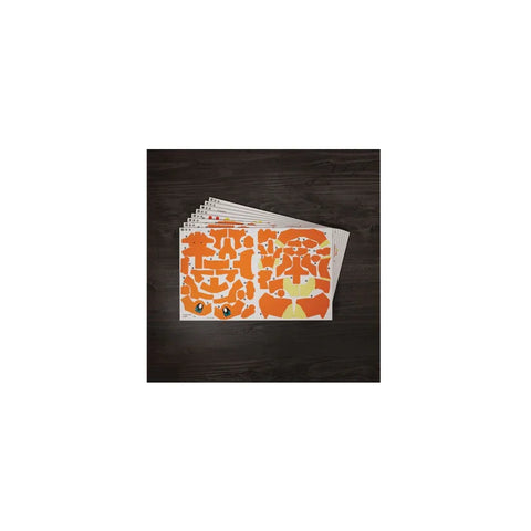 Charmander 3D puzzle model kit sheets with orange pre-cut pieces on a dark table