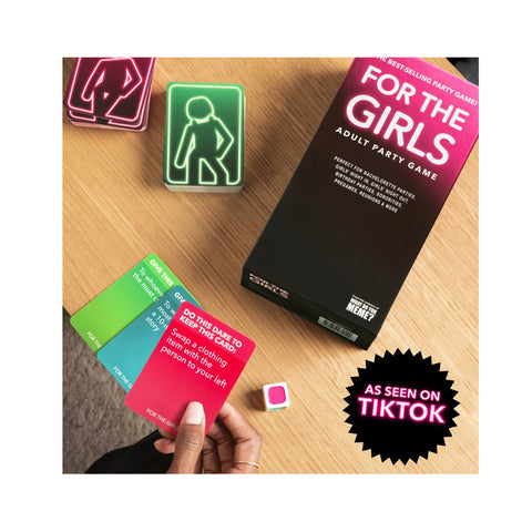 Board game box titled 'For the Girls' with cards and a die on a wooden surface, featuring TikTok branding.