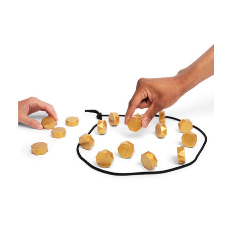 Wooden puzzle pieces on a black string with hands trying to solve it on a white background