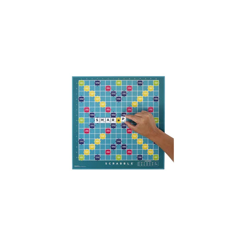 Scrabble board game with hand placing letter tiles on the board